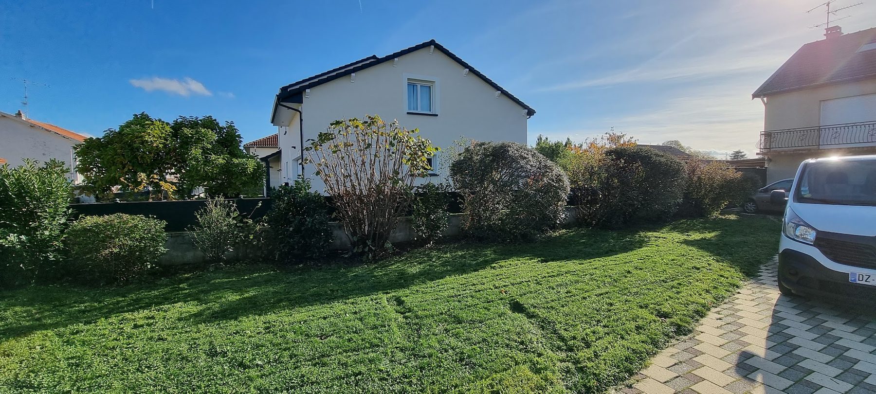 Pelouse tondue et massifs devant une maison