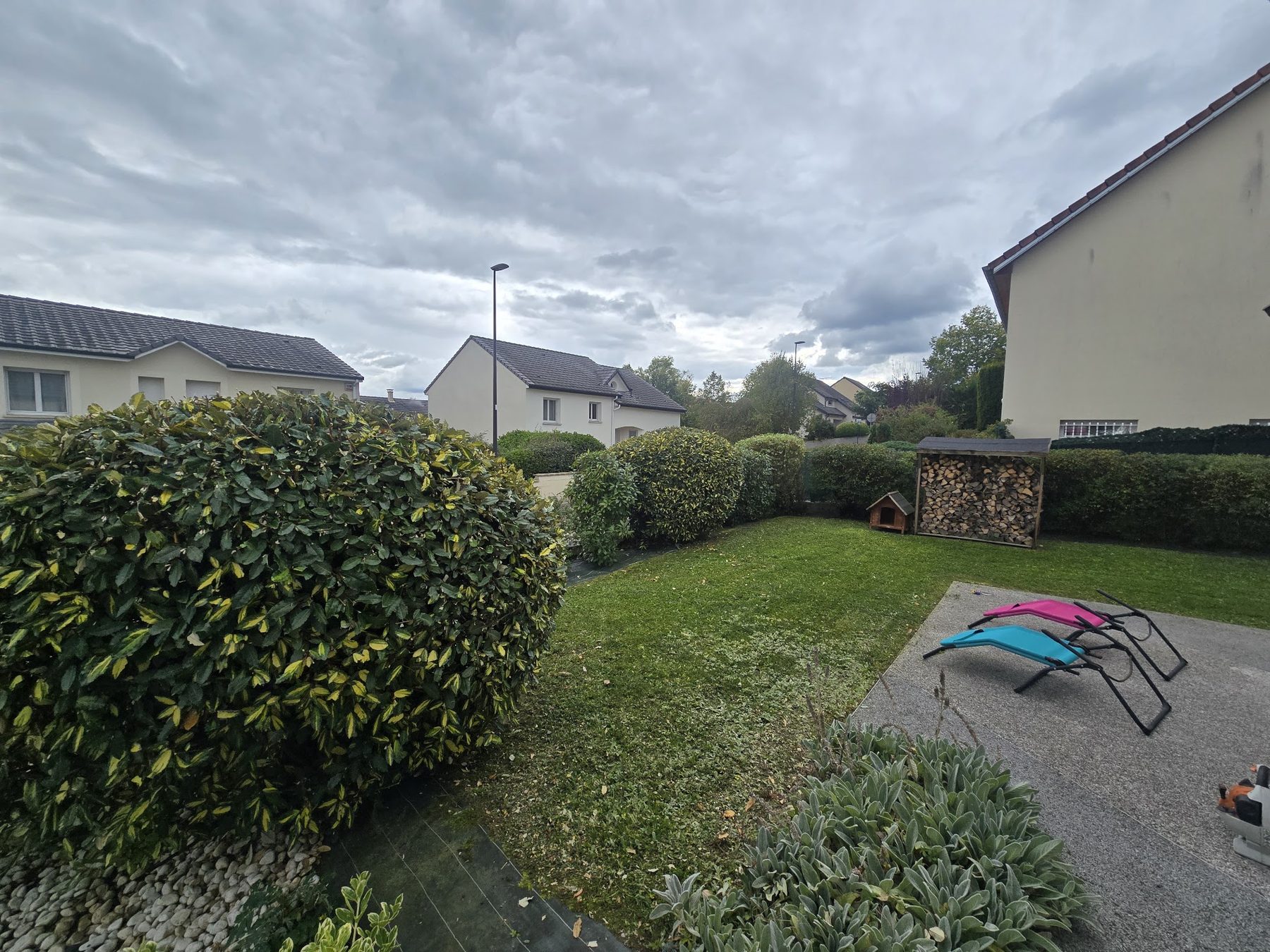 Jardin de lotissement avec pelouse tondue et arbustes taillés en boule